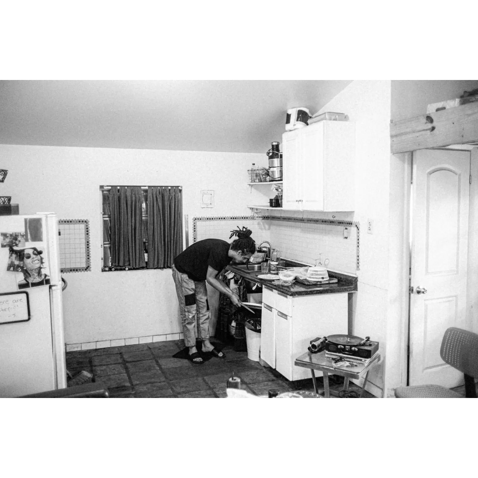 man washing dishes in kitchen