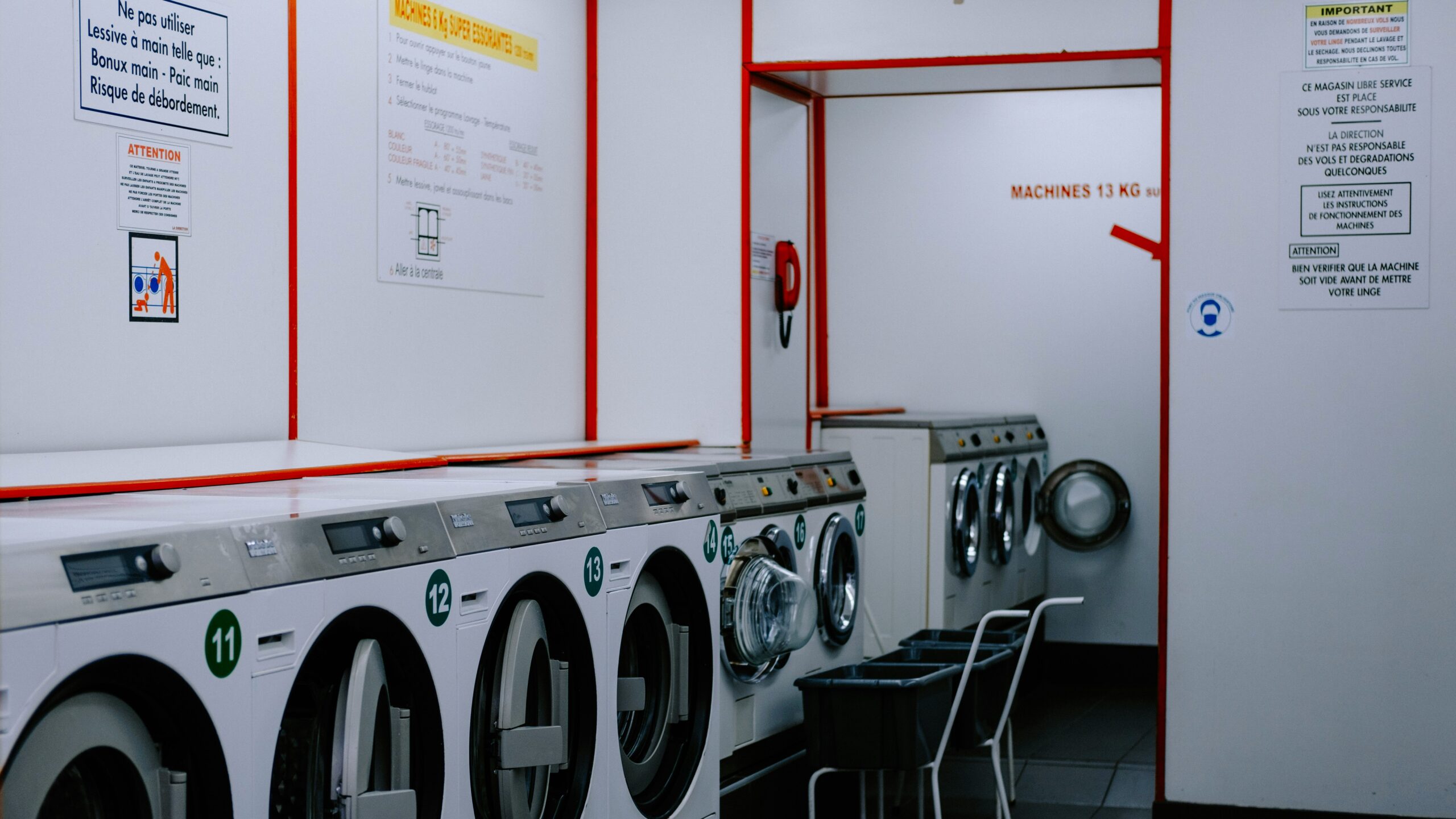 Row of washing machines in laundromat.